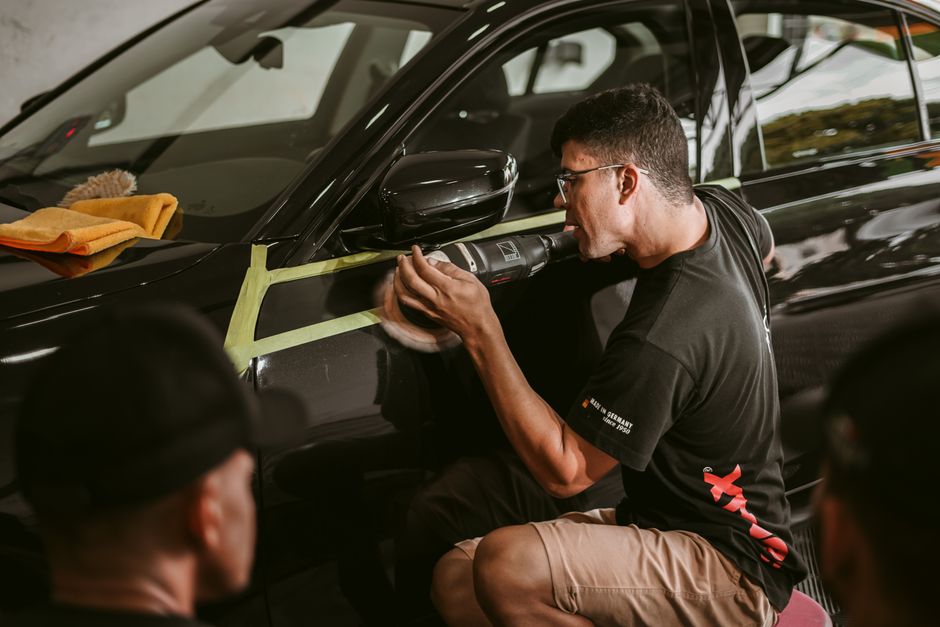 Technician polishing the paint of a luxury vehicle to a high gloss